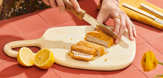 Woman cutting mycelium-based chicken patty.